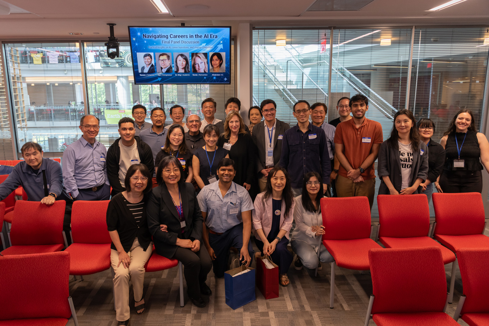 Attendees gather for a group photo in front of the panel-discussion slide.