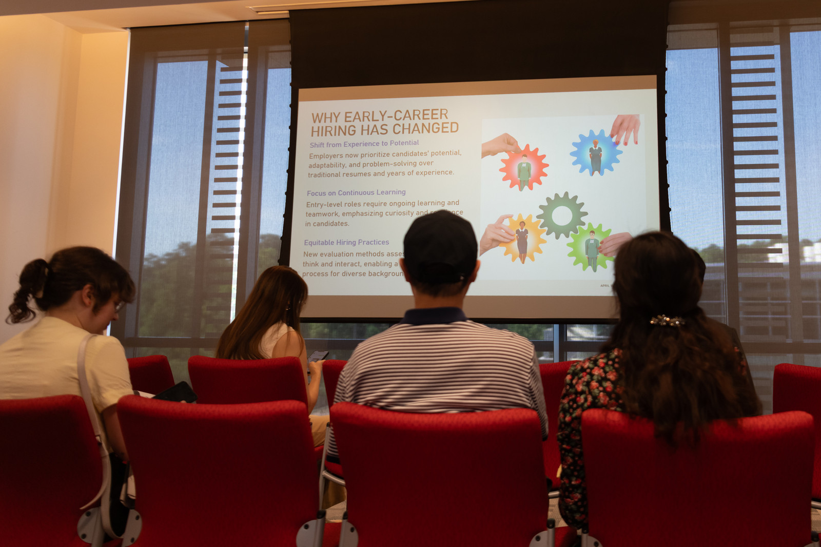 Attendees watch a 'Why Early-Career Hiring Has Changed' slide during a session.