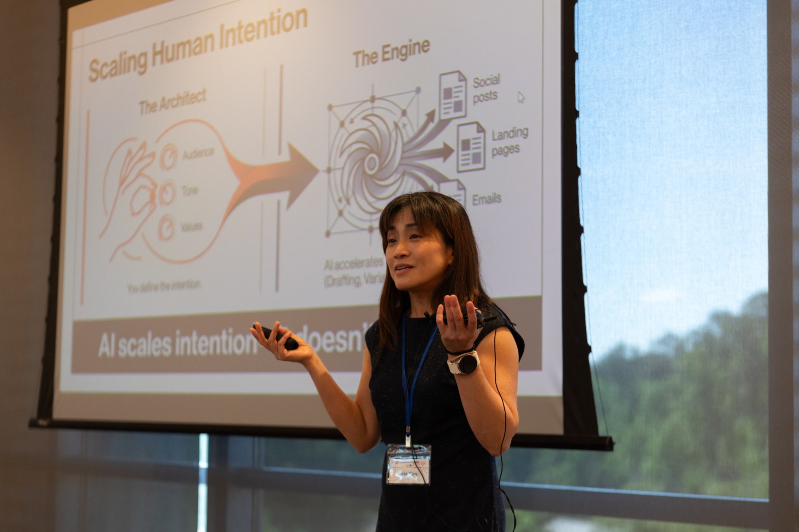 A speaker presents 'Scaling Human Intention,' on using AI as a creative engine while people set the direction.
